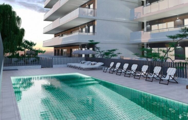 Piscina moderna con tumbonas y árboles.